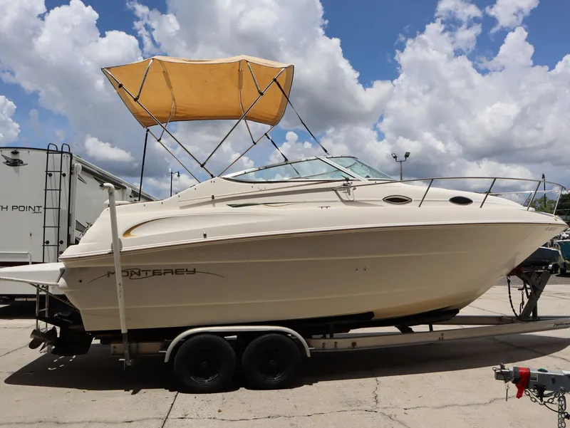 Slide: The Image of 1998 Monterey 242 Cruiser boat on trailer under blue sky. - 5