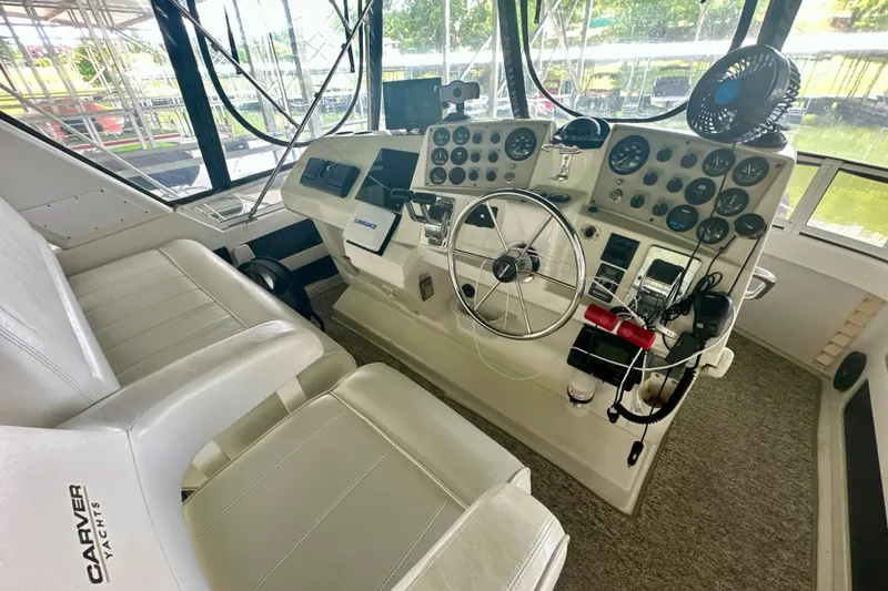 Slide: The Image of 1998 Carver 355 Aft Cabin Motor Yacht helm with steering wheel and control panel. - 10