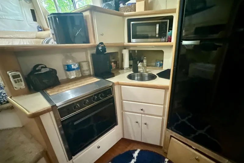 Slide: The Image of Compact kitchen in a 1998 Carver 355 Aft Cabin Motor Yacht with stove, sink, and microwave. - 16
