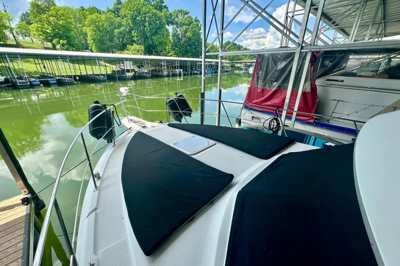 Slide: The Image of 1998 Carver 355 Aft Cabin Motor Yacht docked in a serene marina setting. - 6