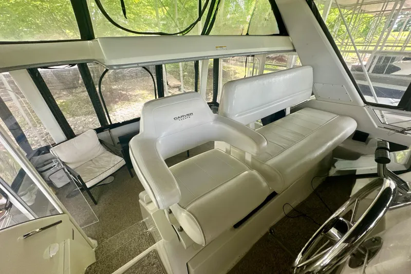 Slide: The Image of Interior of 1998 Carver 355 Aft Cabin Motor Yacht with white seating and helm. - 8