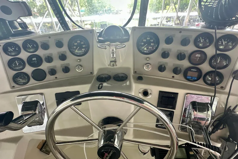 Slide: The Image of Control panel of a 1998 Carver 355 Aft Cabin Motor Yacht with gauges and steering wheel. - 9