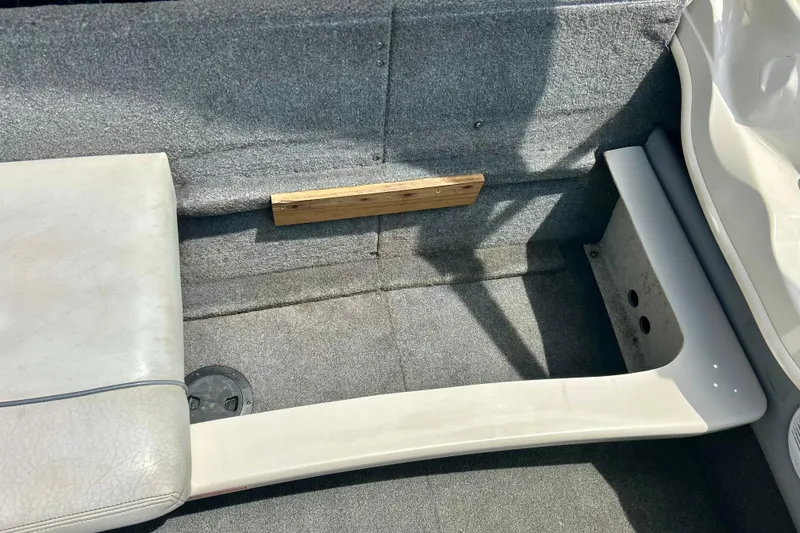 Slide: The Image of Interior of a 2001 Sea Ray 182 Bow Rider boat, featuring gray carpet and seating. - 30