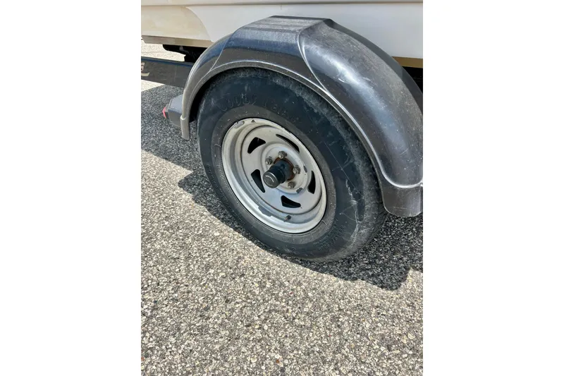 Slide: The Image of Trailer wheel of a 2001 Sea Ray 182 Bow Rider on asphalt surface. - 34