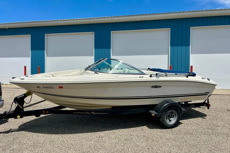 Slide: The Image of 2001 Sea Ray 182 Bow Rider boat on trailer, parked near blue building. - 35
