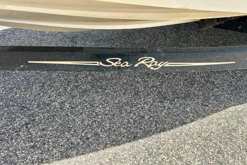 Slide: The Image of 2001 Sea Ray 182 Bow Rider trailer on asphalt, featuring brand logo. - 9