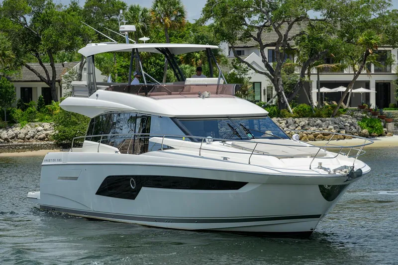 Slide: The Image of Luxury 2021 Prestige 520 yacht cruising near a scenic waterfront property. - 37