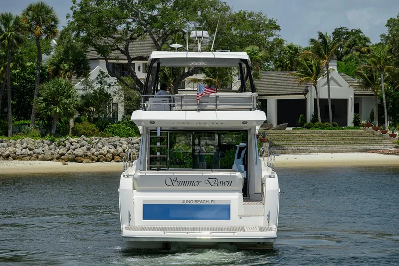 Slide: The Image of 2021 Prestige 520 yacht cruising near a luxurious waterfront property. - 40