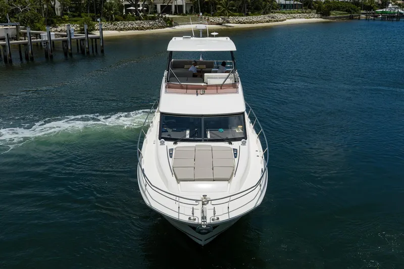 Slide: The Image of Luxury 2021 Prestige 520 yacht cruising on serene waters near a dock. - 42