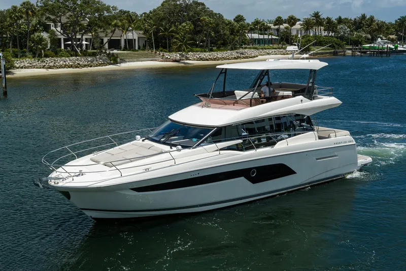 Slide: The Image of Luxury 2021 Prestige 520 yacht cruising on a serene waterway, surrounded by lush greenery. - 43
