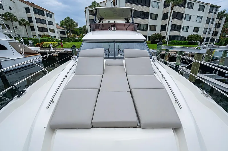 Slide: The Image of Prestige 520 yacht, 2021 model, with sun loungers docked near waterfront apartments. - 47