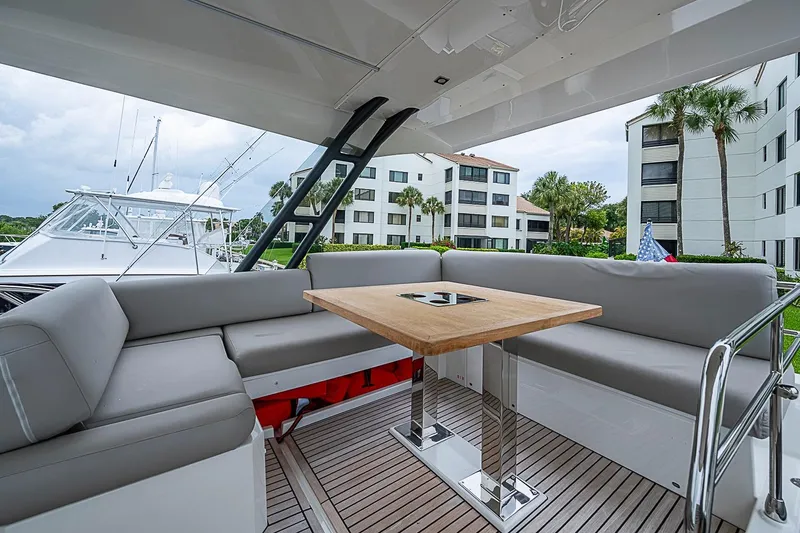 Slide: The Image of Luxurious 2021 Prestige 520 yacht deck with seating and table, docked near modern buildings. - 52