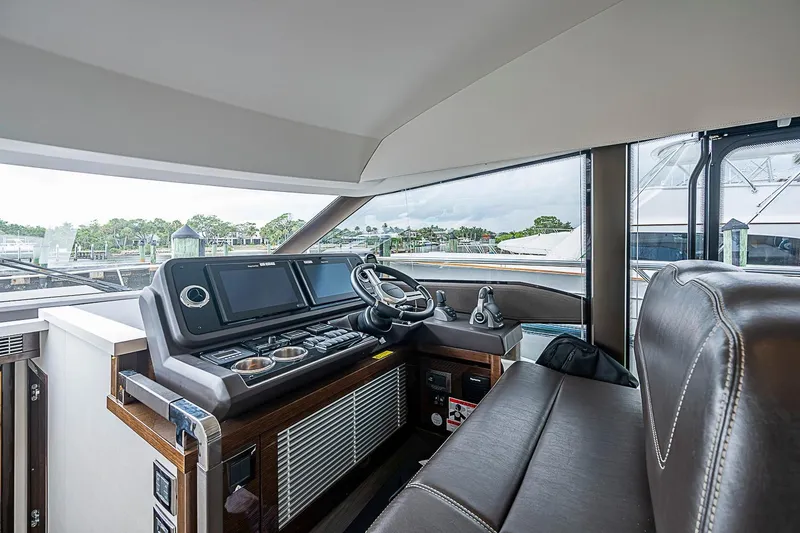 Slide: The Image of Luxurious helm of 2021 Prestige 520 yacht with modern navigation controls and leather seating. - 61