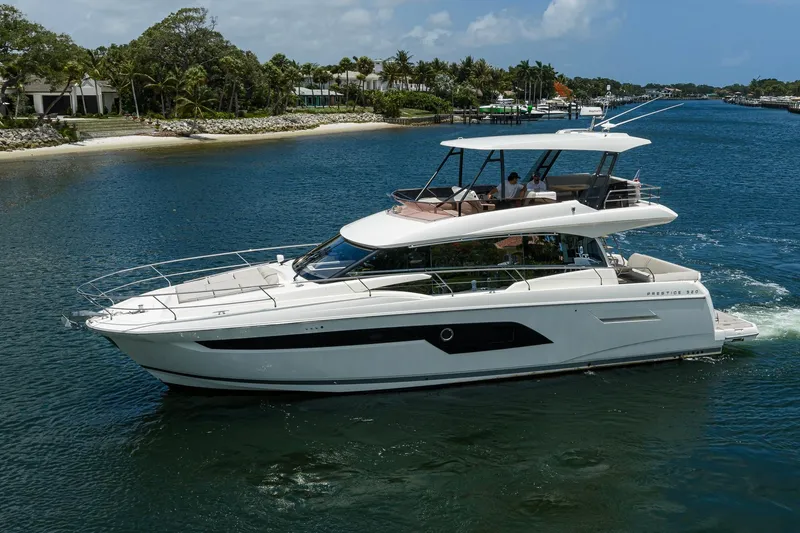Slide: The Image of Luxury 2021 Prestige 520 yacht cruising on a scenic waterway. - 1