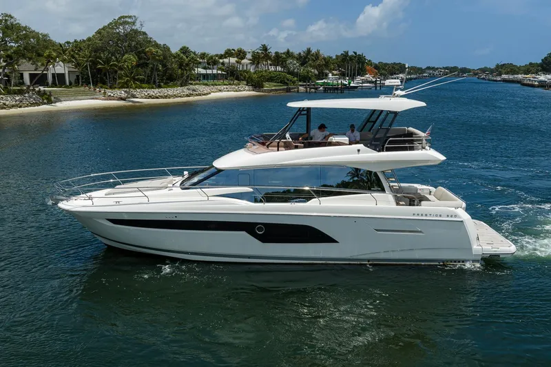 Slide: The Image of Luxury 2021 Prestige 520 yacht cruising near a tropical shoreline. - 40