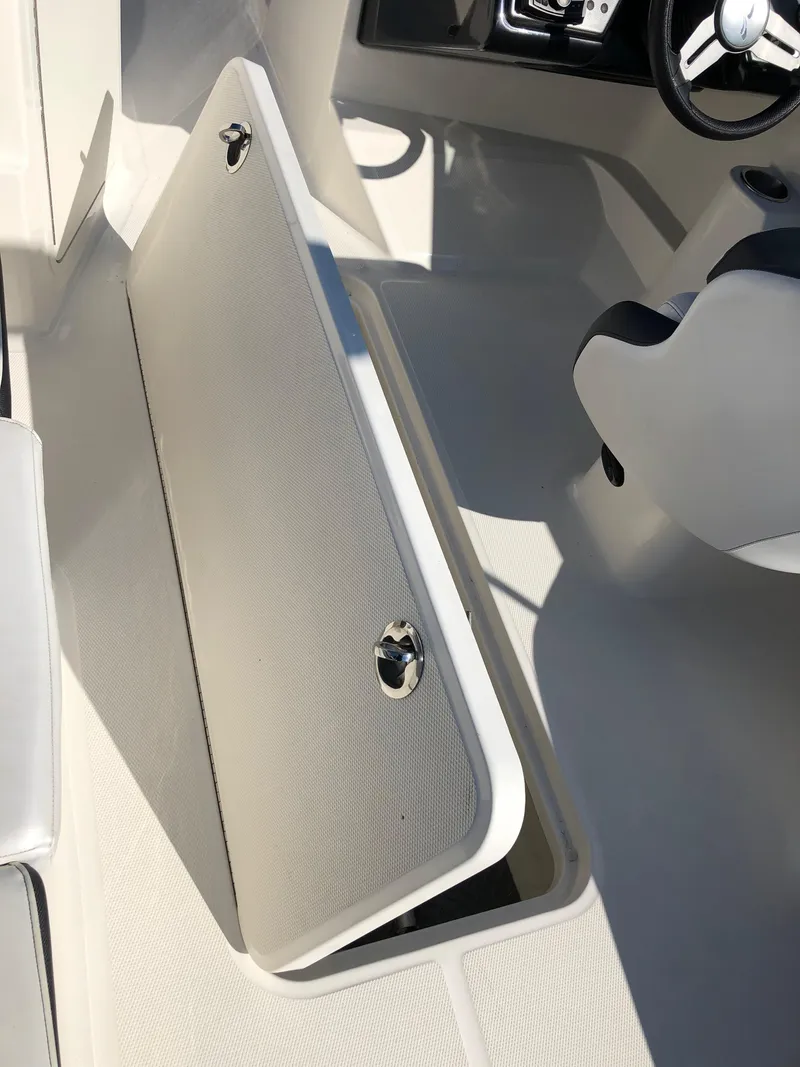 Slide: The Image of Interior of a 2017 Sea Ray 21 SPX boat with open storage hatch. - 21