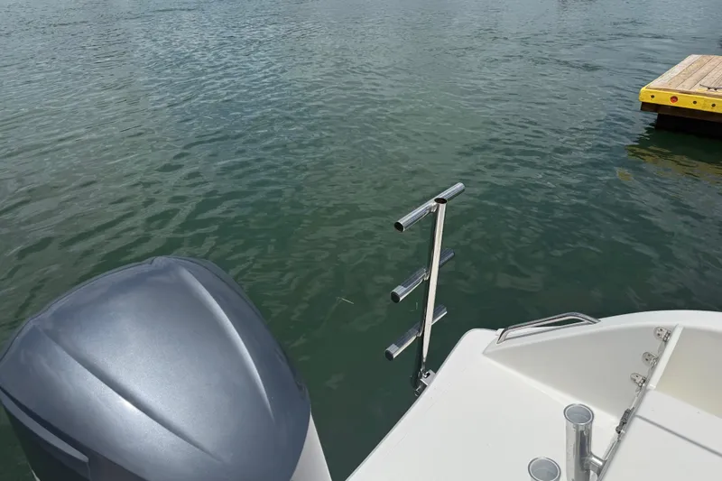 Slide: The Image of 2016 Cape Horn 22 OS boat with motor and rod holders on calm water. - 12