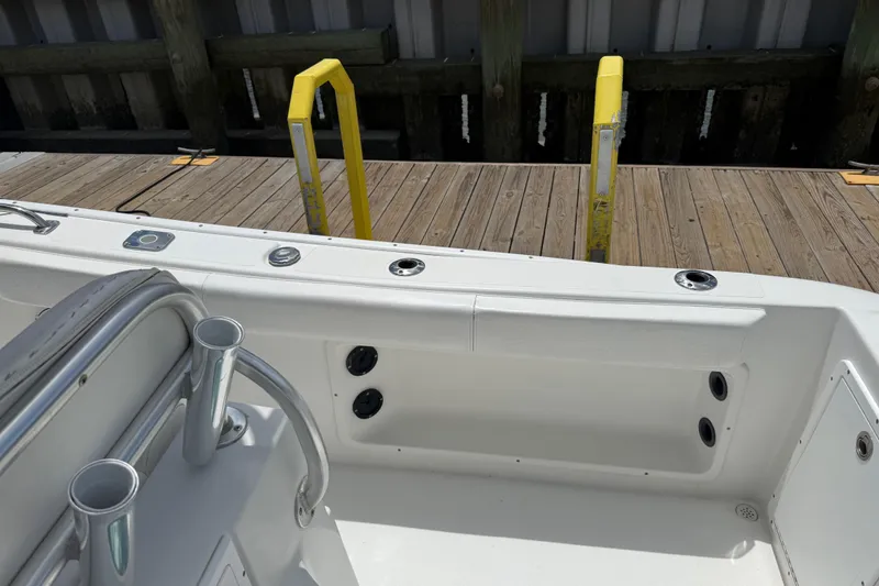 Slide: The Image of 2016 Cape Horn 22 OS boat interior near dock, featuring rod holders and seating. - 18