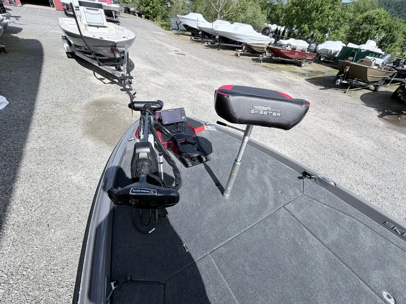 Slide: The Image of Skeeter ZXE21 2026 boat with Minn Kota motor and seat on gravel lot. - 3