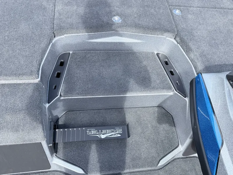 Slide: The Image of Skeeter ZXE20 2026 boat deck with gray carpet and blue trim. - 22