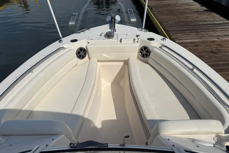 Slide: The Image of 2019 Grady-White Freedom 255 boat interior with white seating and speakers at dock. - 16
