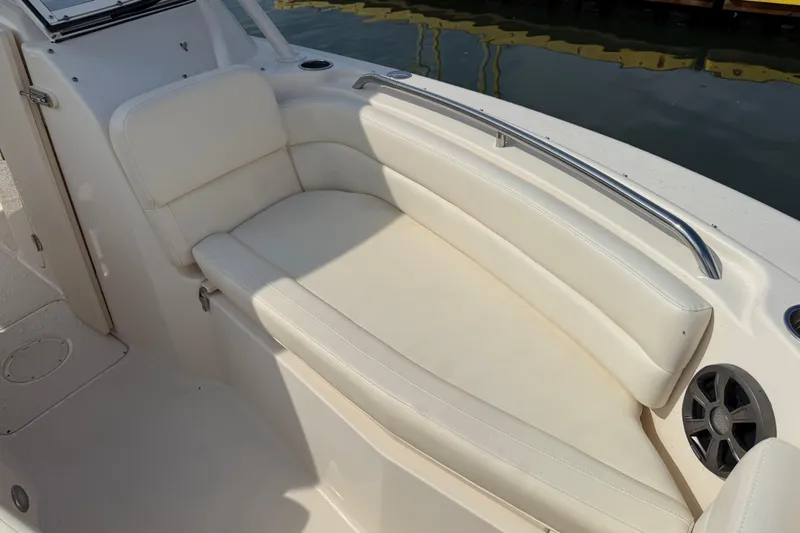 Slide: The Image of 2019 Grady-White Freedom 255 boat interior with white cushioned seating and speaker. - 18