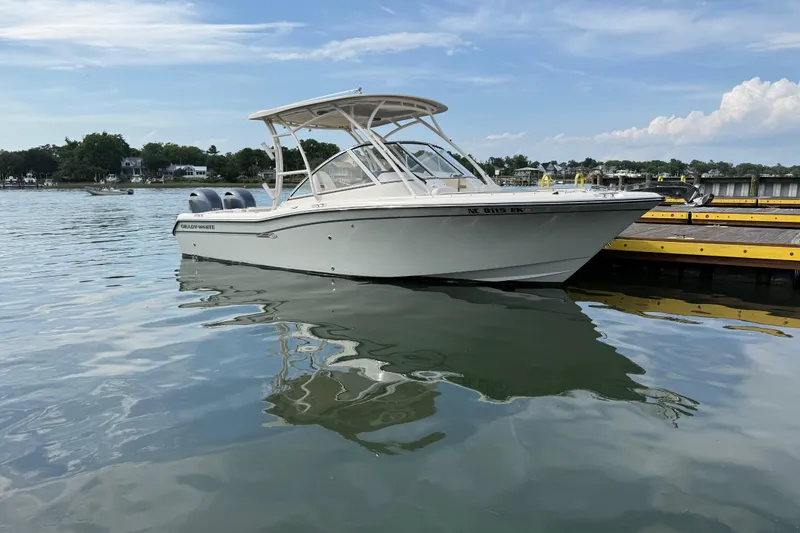 Slide: The Image of 2019 Grady-White Freedom 255 boat docked on calm water under a clear sky. - 2