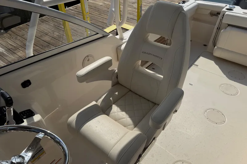 Slide: The Image of 2019 Grady-White Freedom 255 boat interior with beige seating and steering wheel. - 34