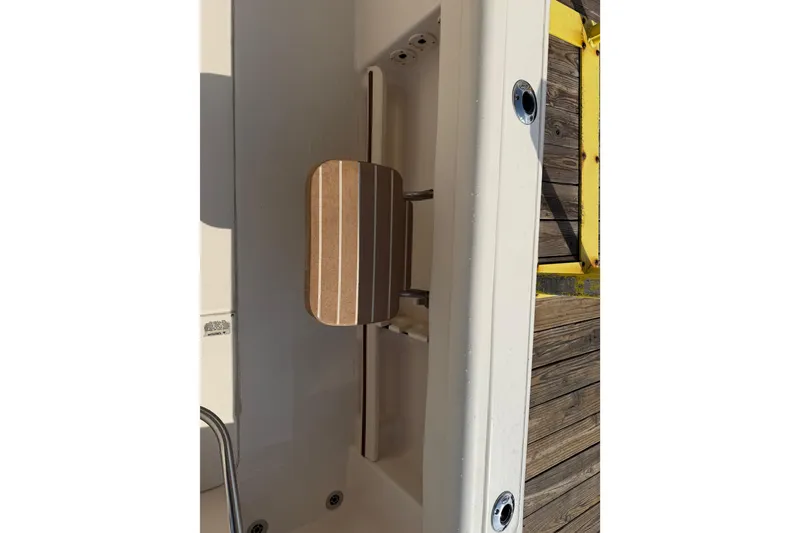 Slide: The Image of 2019 Grady-White Freedom 255 boat interior detail with wooden panel and metal fixtures. - 39