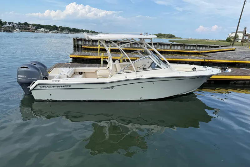 Slide: The Image of 2019 Grady-White Freedom 255 boat docked on calm water, showcasing sleek design. - 4