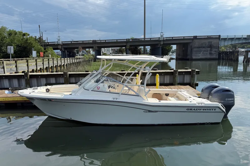 Slide: The Image of 2019 Grady-White Freedom 255 boat docked near a bridge on calm water. - 6