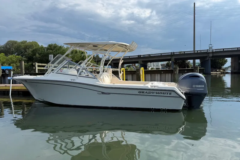 Slide: The Image of 2019 Grady-White Freedom 255 boat docked near a bridge on a calm day. - 7