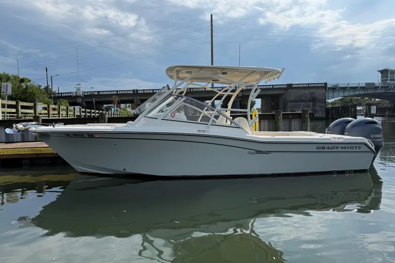 Slide: The Image of 2019 Grady-White Freedom 255 boat docked near a bridge on a calm day. - 8
