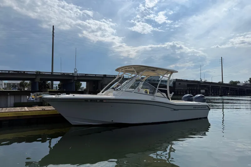 Slide: The Image of 2019 Grady-White Freedom 255 boat docked near a bridge under a cloudy sky. - 9