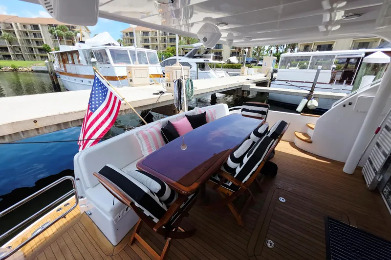Slide: The Image of Luxurious 2008 Hatteras 64 Motor Yacht deck with dining area and American flag. - 10