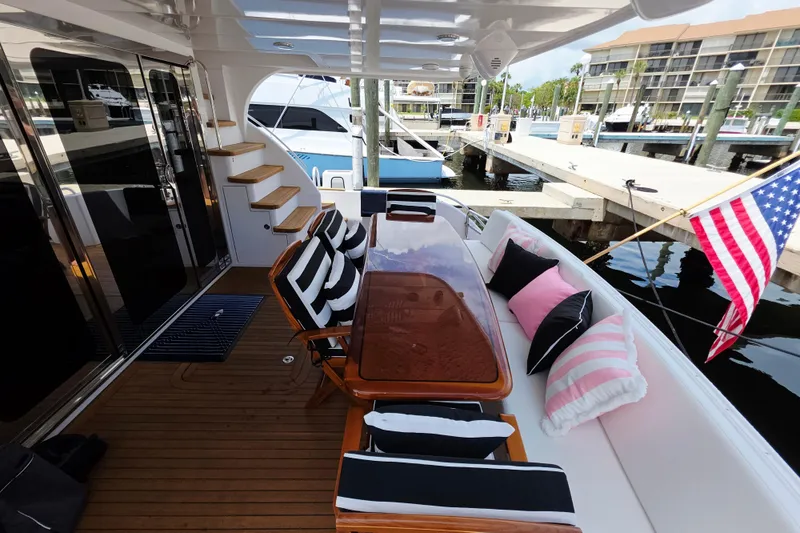 Slide: The Image of Luxurious 2008 Hatteras 64 Motor Yacht deck with elegant seating and American flag. - 11