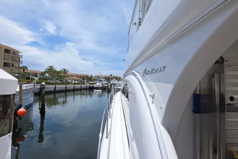 Slide: The Image of 2008 Hatteras 64 Motor Yacht docked in a sunny marina setting. - 14