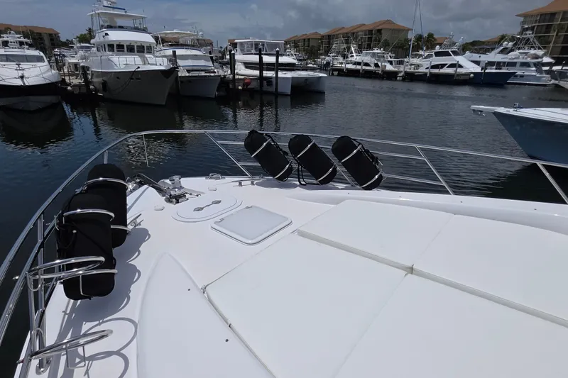 Slide: The Image of 2008 Hatteras 64 Motor Yacht docked in a marina, surrounded by other boats. - 16