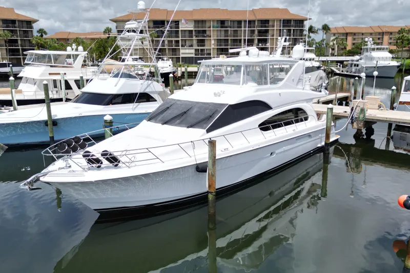 Slide: The Image of 2008 Hatteras 64 Motor Yacht docked in a marina, surrounded by other boats. - 2