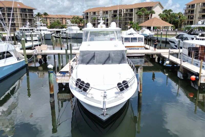 Slide: The Image of 2008 Hatteras 64 Motor Yacht docked in a marina, surrounded by other boats. - 3