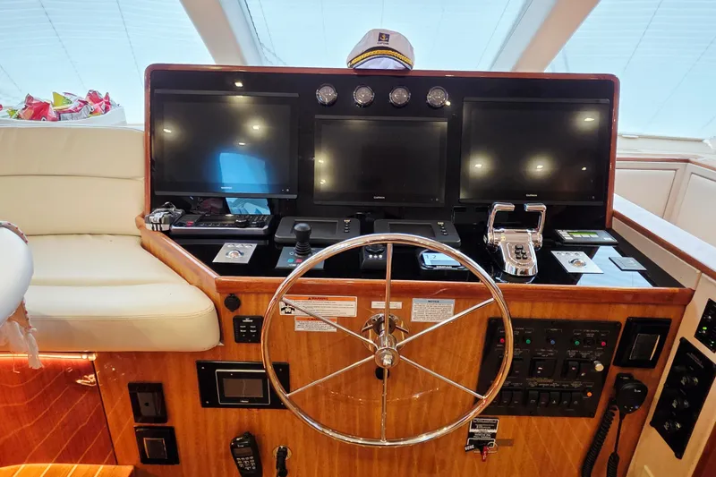 Slide: The Image of 2008 Hatteras 64 Motor Yacht helm with steering wheel and navigation screens. - 33