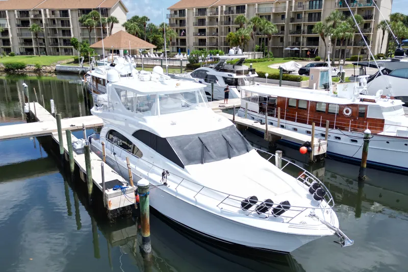 Slide: The Image of 2008 Hatteras 64 Motor Yacht docked in a marina, surrounded by other boats. - 4