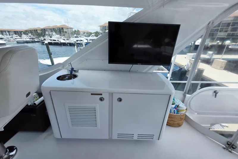 Slide: The Image of 2008 Hatteras 64 Motor Yacht interior with sink, TV, and marina view. - 49