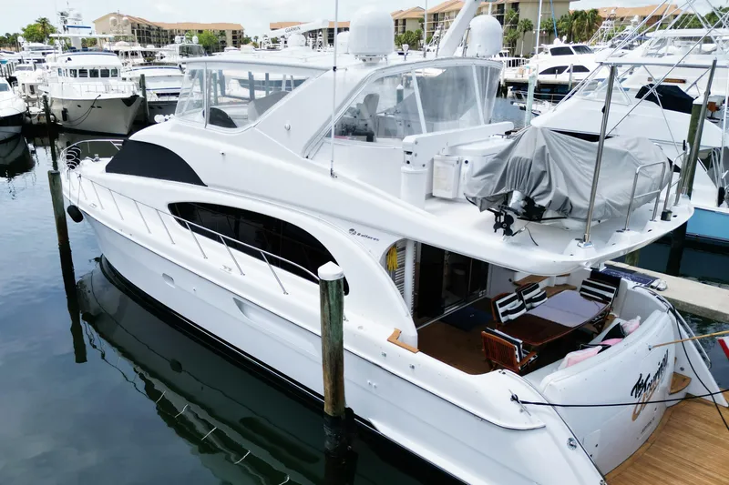 Slide: The Image of 2008 Hatteras 64 Motor Yacht docked at marina, featuring spacious deck and sleek design. - 5