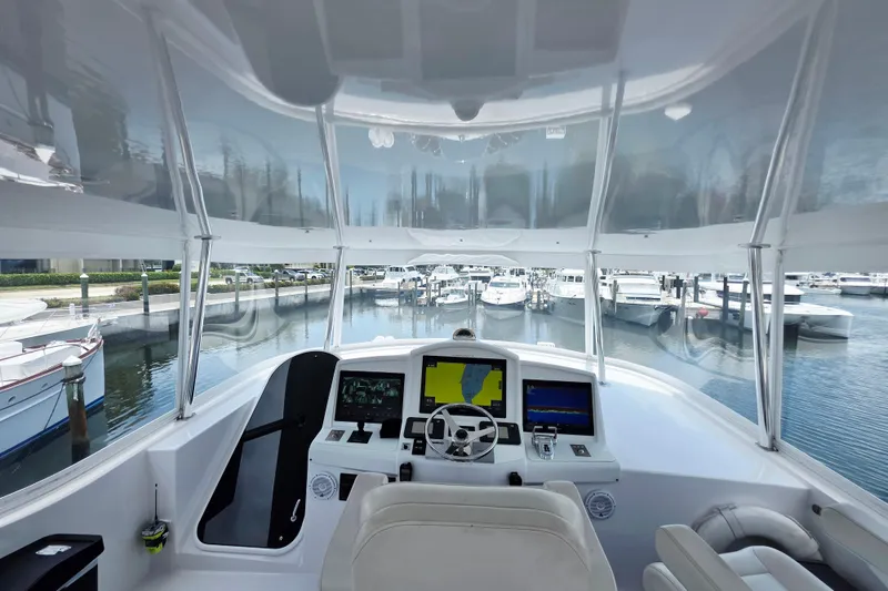 Slide: The Image of 2008 Hatteras 64 Motor Yacht helm with marina view, featuring advanced navigation systems. - 50