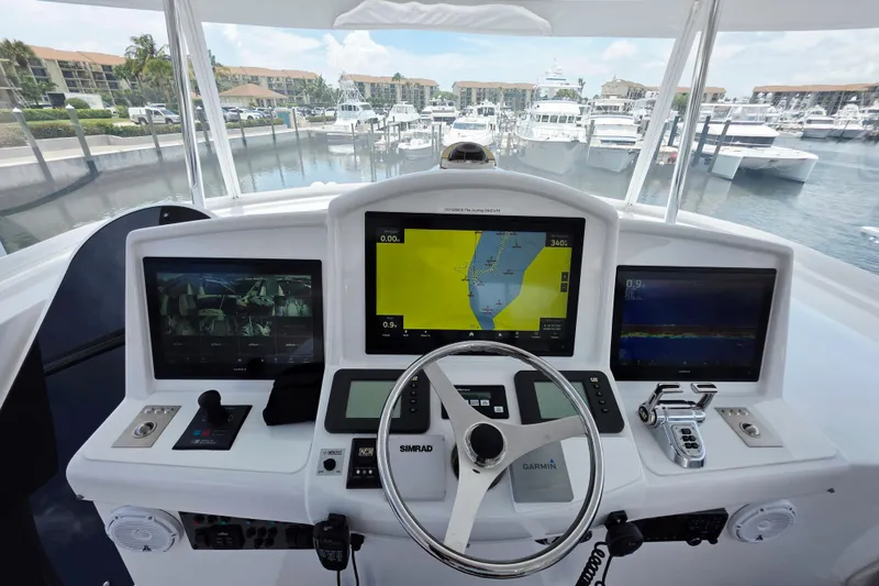 Slide: The Image of Helm of 2008 Hatteras 64 Motor Yacht with advanced navigation displays in marina setting. - 51