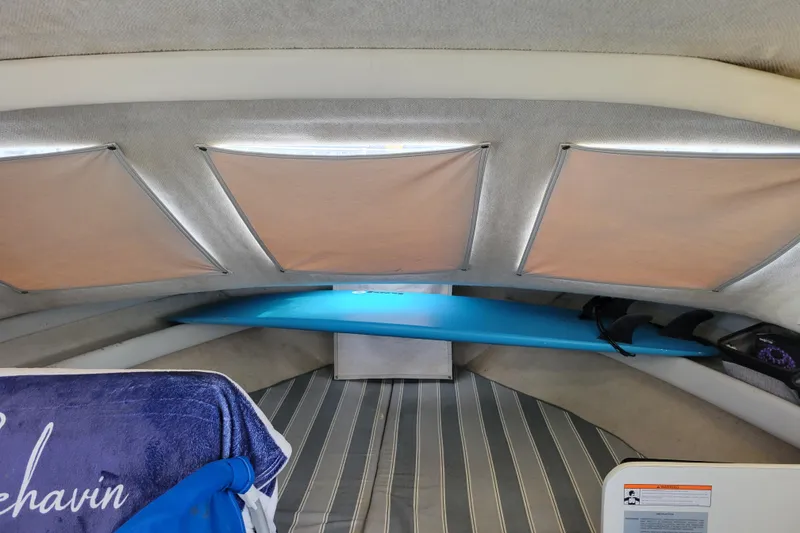 Slide: The Image of Interior cabin of 1993 Bayliner 2859 Ciera Classic with striped bedding and surfboard. - 10