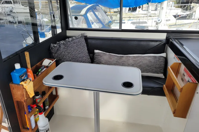 Slide: The Image of Interior of 1993 Bayliner 2859 Ciera Classic with table, seating, and storage shelves. - 7
