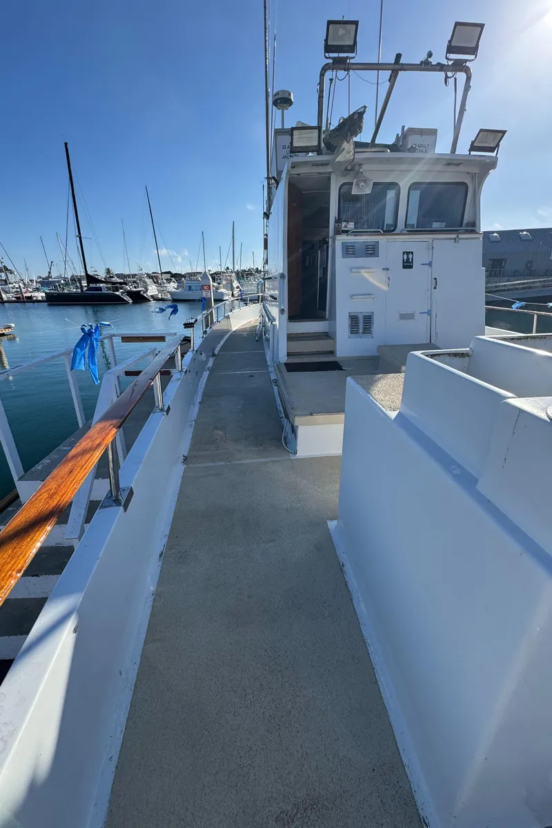 Slide: The Image of 1966 Seaway Commercial Sportfish Vessel docked, showcasing side deck and cabin in a marina setting. - 13