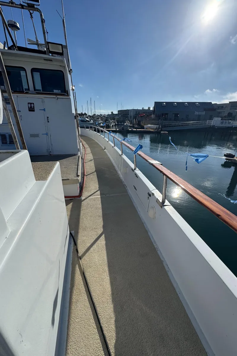 Slide: The Image of 1966 Seaway Commercial Sportfish Vessel docked, showcasing side deck and marina view. - 14